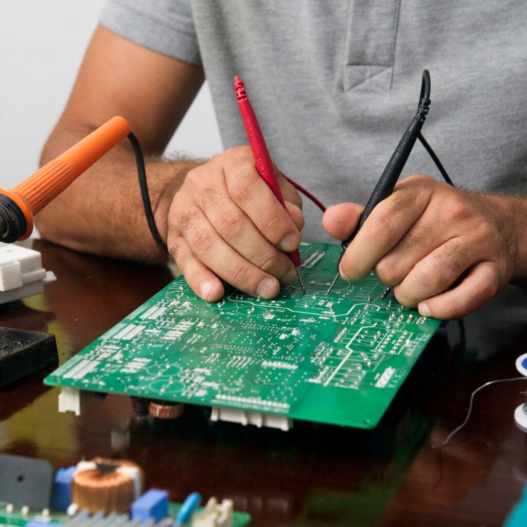 Professional medical device repair technician calibrating diagnostic equipment, Expert medical device repair specialist performing precision testing on patient monitor